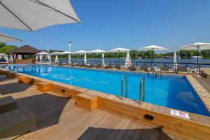 a large swimming pool with chairs and umbrellas at SPA Hotel Galera in Kyiv