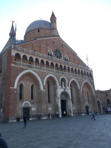 ein großes Backsteingebäude mit einer Uhr drauf in der Unterkunft Ciao Amore in Padua
