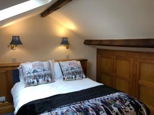 a bedroom with a bed with two pillows on it at Calf's Head Hotel in Clitheroe