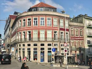 波尔图Sé Boutique Apartment的一条城市街道上的红色和白色大建筑