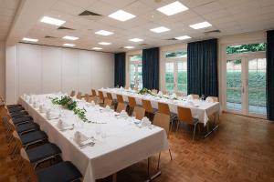 a conference room with white tables and chairs at Hotel Haus Chorin in Chorin