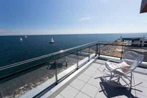 a balcony with a chair and a view of the ocean at Komfort-Ferienwohnung Waterkant by Meer-Ferienwohnungen in Olpenitz