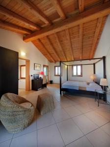 a large bedroom with a bed and a wooden ceiling at Il Milione Country Hotel in Palazzolo dello Stella