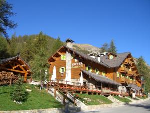 a large wooden building with a mountain at Hotel Chamois d'Or in Tende