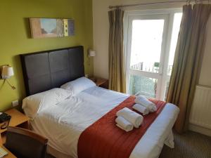 a bedroom with a bed with two towels on it at Rose And Crown in Porthcawl