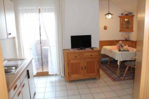 a kitchen with a television and a table with a tableablish at Appartementhaus "Haflinger Hof" in Bad Füssing