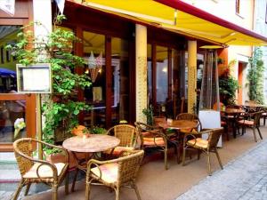 eine Außenterrasse mit Tischen und Stühlen sowie ein Restaurant in der Unterkunft Ferienwohnung Albrecht Sonnendeck in Bad Schandau