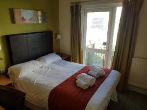 a hotel room with a bed with towels on it at Rose And Crown in Porthcawl