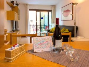 una botella de vino y una caja en una mesa en Apartment Primer de Maig by Interhome, en Sitges