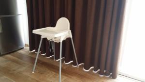 - une chaise haute blanche devant un rideau dans l'établissement Apartamento Sur Monseñor, à Playa del Cura