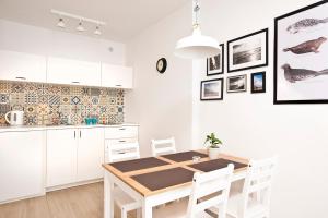 a kitchen with white cabinets and a wooden table at Heaven in Hel 1 in Hel