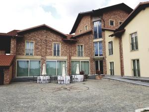 a courtyard with tables and umbrellas in front of a building at Cascina Speranza Hotel in Riva presso Chieri