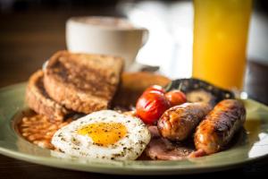 a plate of breakfast food with eggs sausage and toast at Rose And Crown in Porthcawl