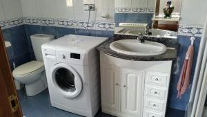 a bathroom with a washing machine and a sink at PISO HARLEY in Camariñas