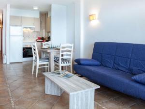 a living room with a blue couch and a table at Apartment Fanals-8 by Interhome in Platja d'Aro