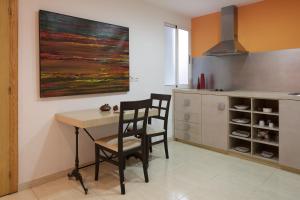 a kitchen with a table and two chairs and a painting at Hotel Alamo in Alicante