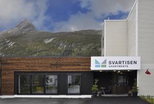 a building with a mountain in the background at Svartisen Apartments in Glomfjord