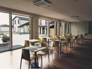 a dining room with tables and chairs and windows at Cascina Speranza Hotel in Riva presso Chieri