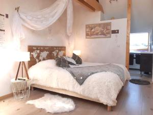 a bedroom with a bed with a canopy at La Maison Rouge Ladoix - Proche Beaune in Ladoix Serrigny
