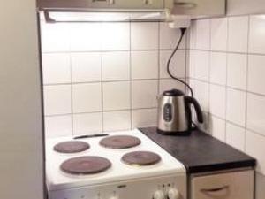 a stove in a kitchen with a tea kettle on it at Holiday Home Pihlajatupa by Interhome in Kittilä