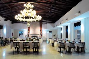 a banquet hall with tables and chairs and a chandelier at Parque Hotel in Villa Carlos Paz