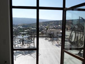 Blick aus einem Fenster auf eine Terrasse mit Tischen und Stühlen in der Unterkunft Hotel Avlabari Terrace in Tbilisi City
