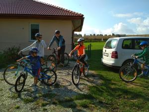 grupa dzieci jeżdżących rowerami na podwórku w obiekcie Holiday House Adrelot w mieście Heřmaničky