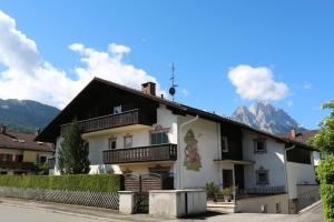 una casa grande con montañas al fondo en Mountain View Apartment, en Garmisch-Partenkirchen