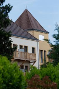 um edifício com uma varanda e um telhado em Médicis Home Paray le Monial em Paray-le-Monial