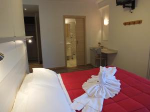 1 dormitorio con 1 cama con manta roja en Hotel alle Rose, en Cavedago