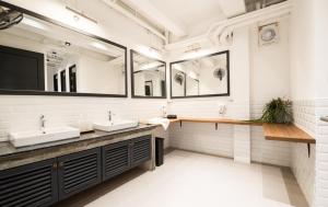 a bathroom with two sinks and two mirrors at Warm Window Silom in Bangkok