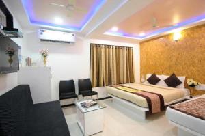 a hotel room with a bed and a couch at Hotel Vyankatesh & Pure Veg Restaurant in Mahabaleshwar