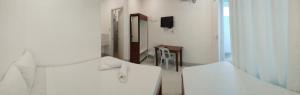 Habitación blanca con espejo y lavabo en Neela Tourist Lodge, en El Nido 14 fotos más