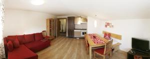 a living room with a red couch and a table at Haus Schmetterling in Alpbach