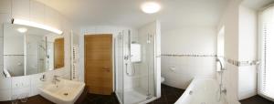 a bathroom with a shower and a sink and a bath tub at Haus Schmetterling in Alpbach +61 photos