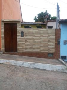 valla de madera con puerta de madera al lado de un edificio en Casa da Ú en Lençóis