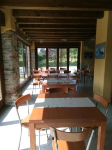 eine Cafeteria mit Holztischen und -stühlen in einem Gebäude in der Unterkunft La Via del Sale in Sanfront