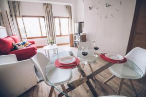 sala de estar con mesa de cristal y sillas en VUT elBALCONdelHUECAR, en Cuenca