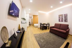 ein Wohnzimmer mit einem Sofa und einem Tisch in der Unterkunft Bugalha My Loft Douro 3 in Peso da Régua