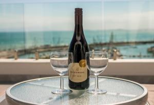 高登灣的住宿－Bikini Beach Penthouse，桌子上放有一瓶葡萄酒和两杯酒