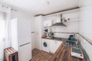 クエンカにあるVUT elBALCONdelHUECARのキッチン(白いキャビネット、洗濯機、乾燥機付)