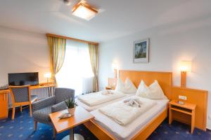 ein Hotelzimmer mit 2 Betten und einem Schreibtisch in der Unterkunft Gasthof Oberer Gesslbauer in Stanz Im Murztal