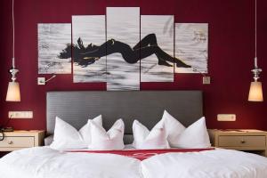 a bedroom with a bed and a wall with paintings at ... mein romantisches Hotel Toalstock in Fiss