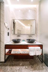 a bathroom with two sinks and a large mirror at AKVO Hotel in Hong Kong