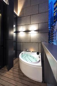 a bath tub in a bathroom with a city at AKVO Hotel in Hong Kong