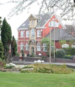 een groot rood gebouw met een klokkentoren erop bij Carnegie Library: Bronte Apartment 1 bedroom in Swinton