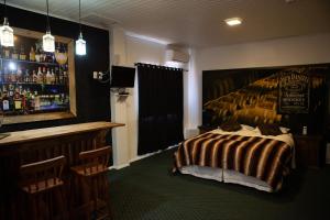 a hotel room with a bed and a bar at Pousada Serra Azul in Urubici