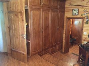a room with wooden cabinets and a room with a table at Диброва in Dibrova