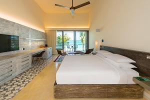 a bedroom with a large bed and a flat screen tv at Andaz Mayakoba All Inclusive Package in Playa del Carmen