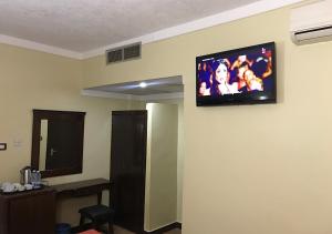 TV de pantalla plana en la pared de una habitación en hidab petra en Wadi Musa
